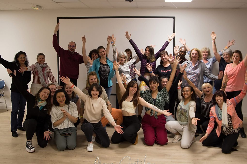 Un groupe d'une trentaine de participants, bras levés, à la fin d'un atelier de préparation mentale de Marine Valet