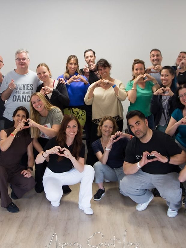 Les participants d'un atelier formant un coeur avec les mains